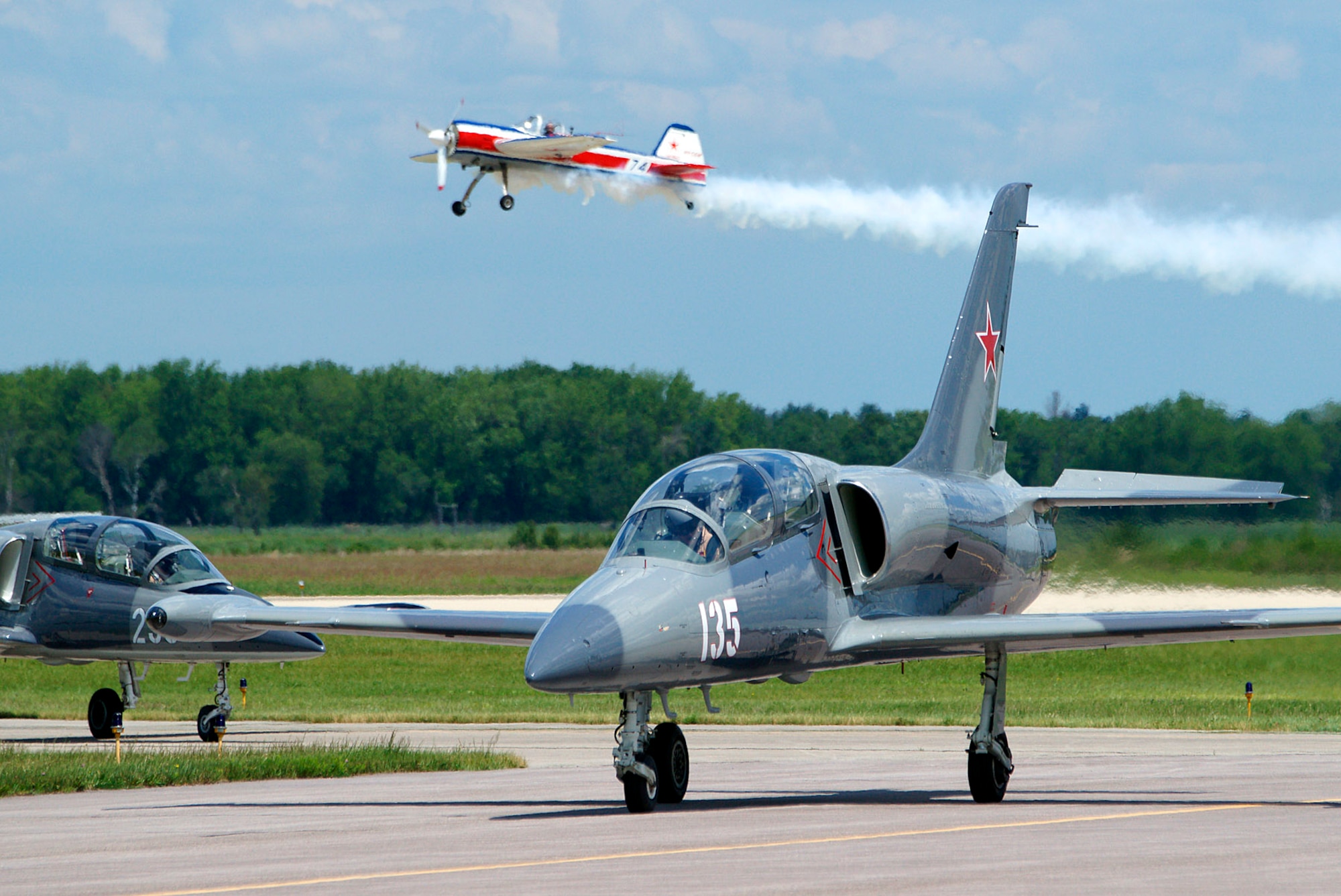 Airshow pilot Bill Cowden begins his performance at the 2012 Volk Field Open House as the Hopper Jet Demonstration Team taxis in after their performance.  Photo by Joe Oliva,