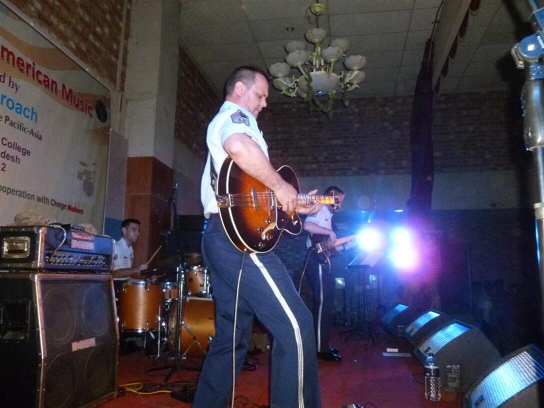US Air Force Master Sgt. Gary Rosenak performs a solo on the gutar during an event by Final Approach, a trio of musicians from the US Air Force Band of the Pacific-Asia .  The ensemble performed for over 900 dignitaries and guests for the US Embassy Dhaka's "National Day" celebration and for over 500 college students during a trip to Bangladesh.