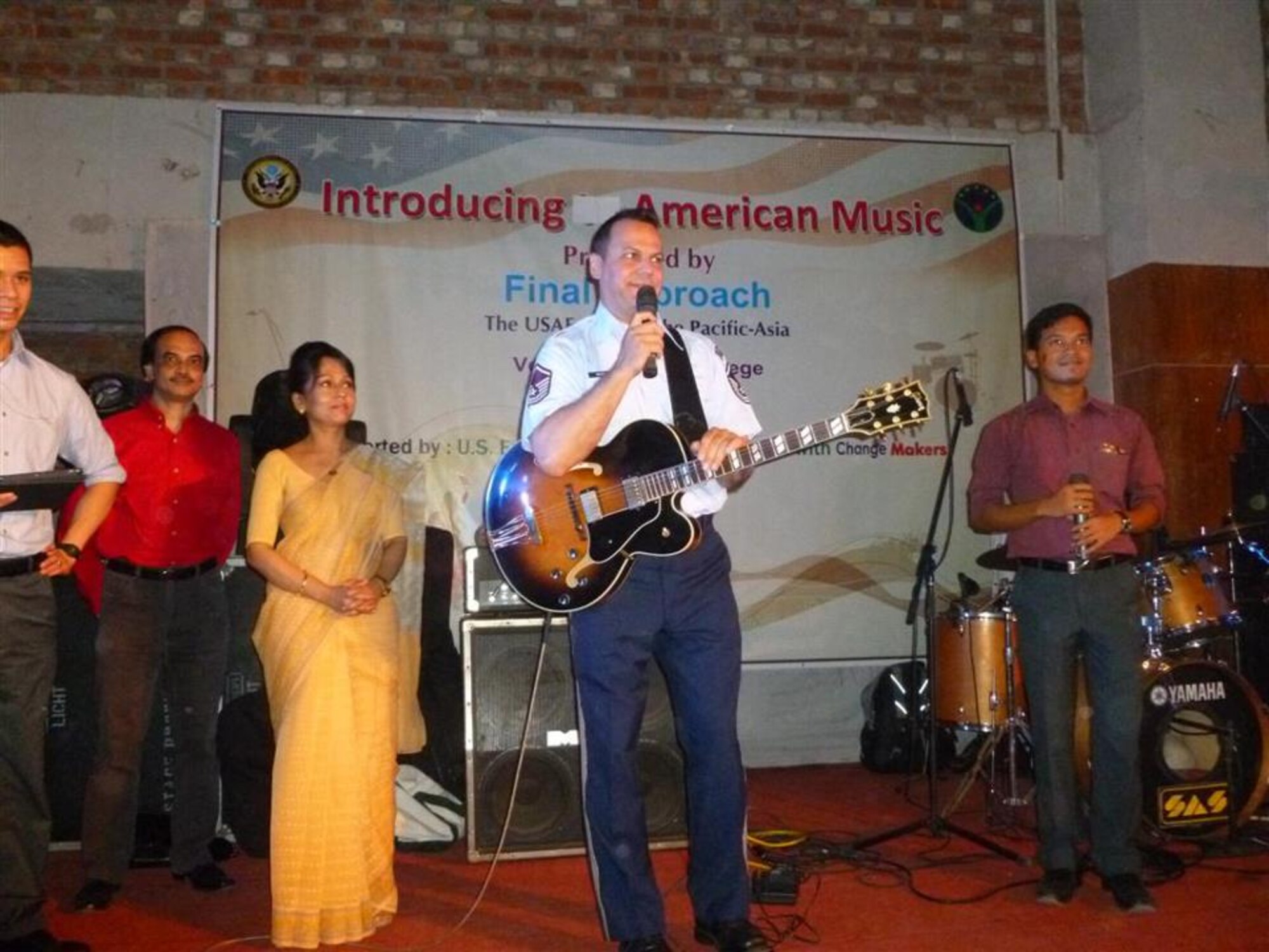 US Air Force Master Sgt. Gary Rosenak addresses the audience during a performance by Final Approach in Bangladesh.  The ensemble performed for over 900 dignitaries and guests for the US Embassy Dhaka's "National Day" celebration and for over 500 college students.