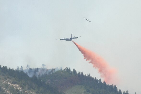 COLORADO SPRINGS, Colo. - A U.S. Forest Service aircraft breaks away as a Modular Airborne Fire Fighting System-equipped C-130 begins dropping retardant on a section of the Waldo Canyon fire near Colorado Springs, Colo., June 26. Four MAFFS units from the 302nd and 153rd Airlift Wings are flying in support of the U.S. Forest Service as they fight wildland fires in Colorado. (U.S. Air Force photo by Tech. Sgt. Thomas J. Doscher)