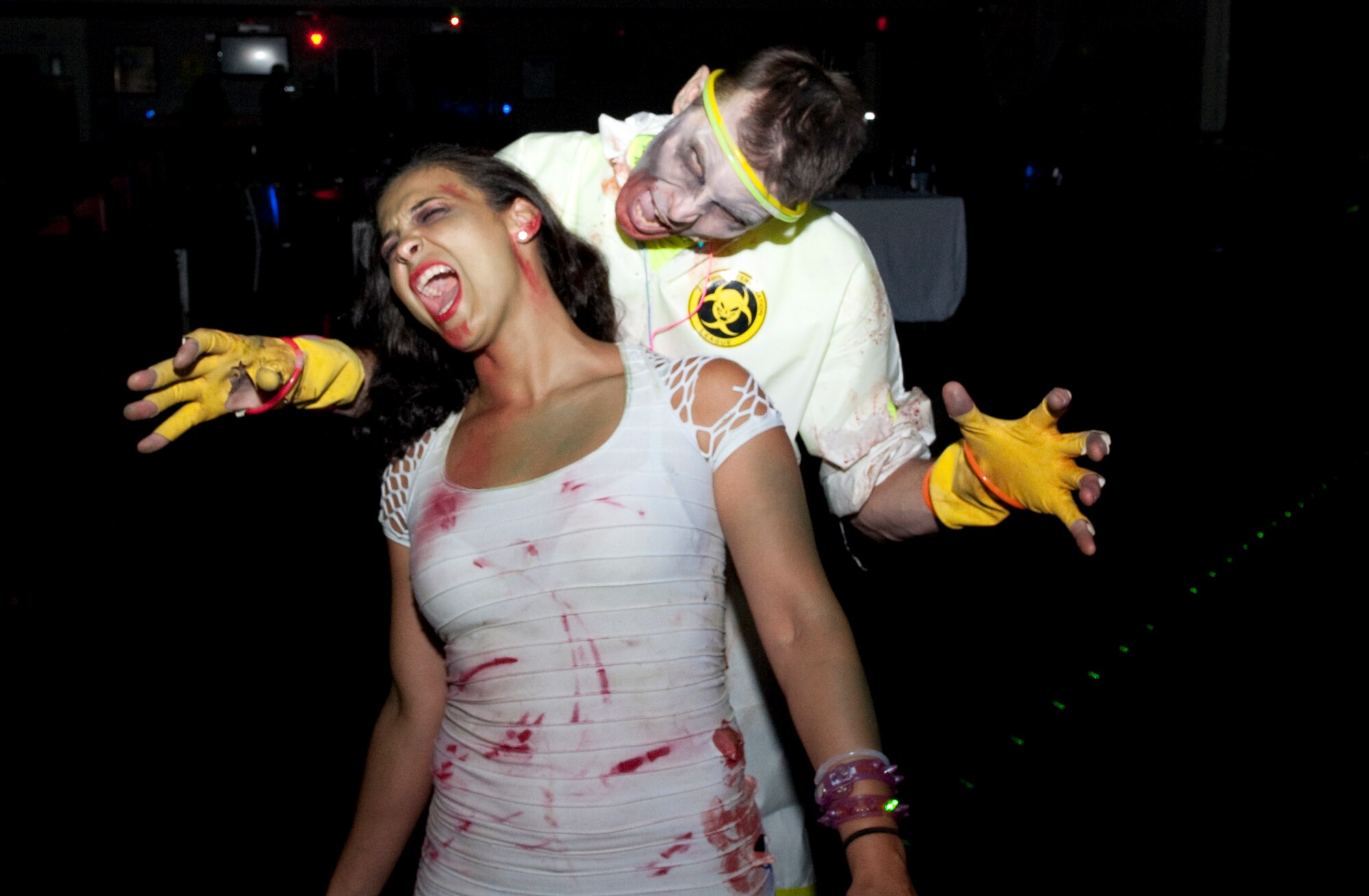 Robert Scott, director of the Landing Zone Community Center, takes a bite out of Airman 1st Class Brandy Dirr, 1st Special Operations Wing Public Affairs, at the Zombie Rave at the Landing Zone at Hurlburt Field, Fla., June 22, 2012. Participants of the free Zombie Rave donned make-up and costumes and danced the night away. (U.S. Air Force photo/Airman 1st Class Benjamin D. Kim)(RELEASED)