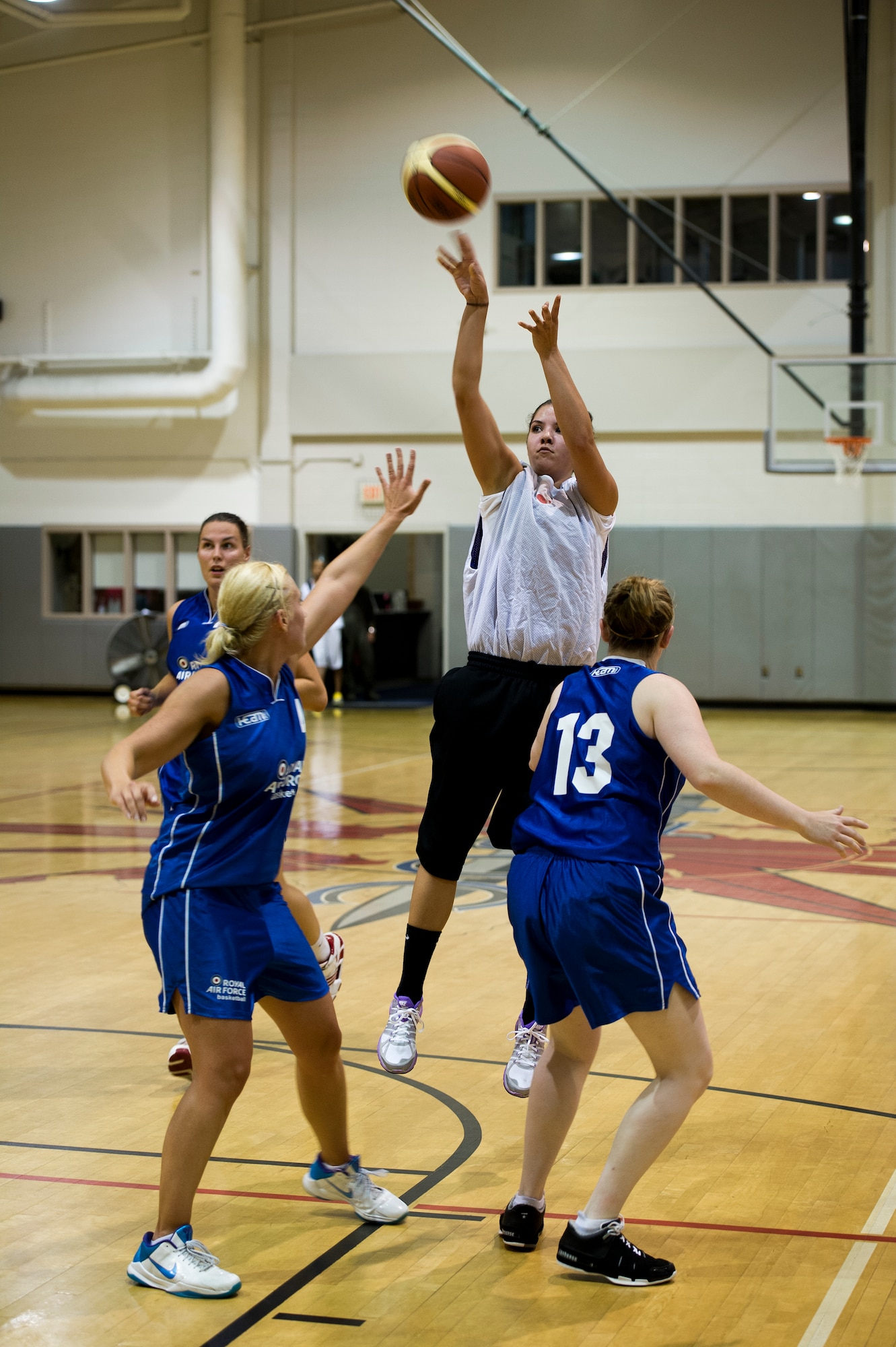 Kristin Rogers, a player for the Hurlburt Field basketball team, shoots over two U.K. Royal Air Force defenders during a scrimmage at the Aderholt Gym on Hurlburt Field, Fla., June 19, 2012. The men's and women's RAF basketball teams scrimmaged multiple times during a two-week training camp. (U.S. Air Force photo by Airman 1st Class Christopher Williams) (RELEASED)