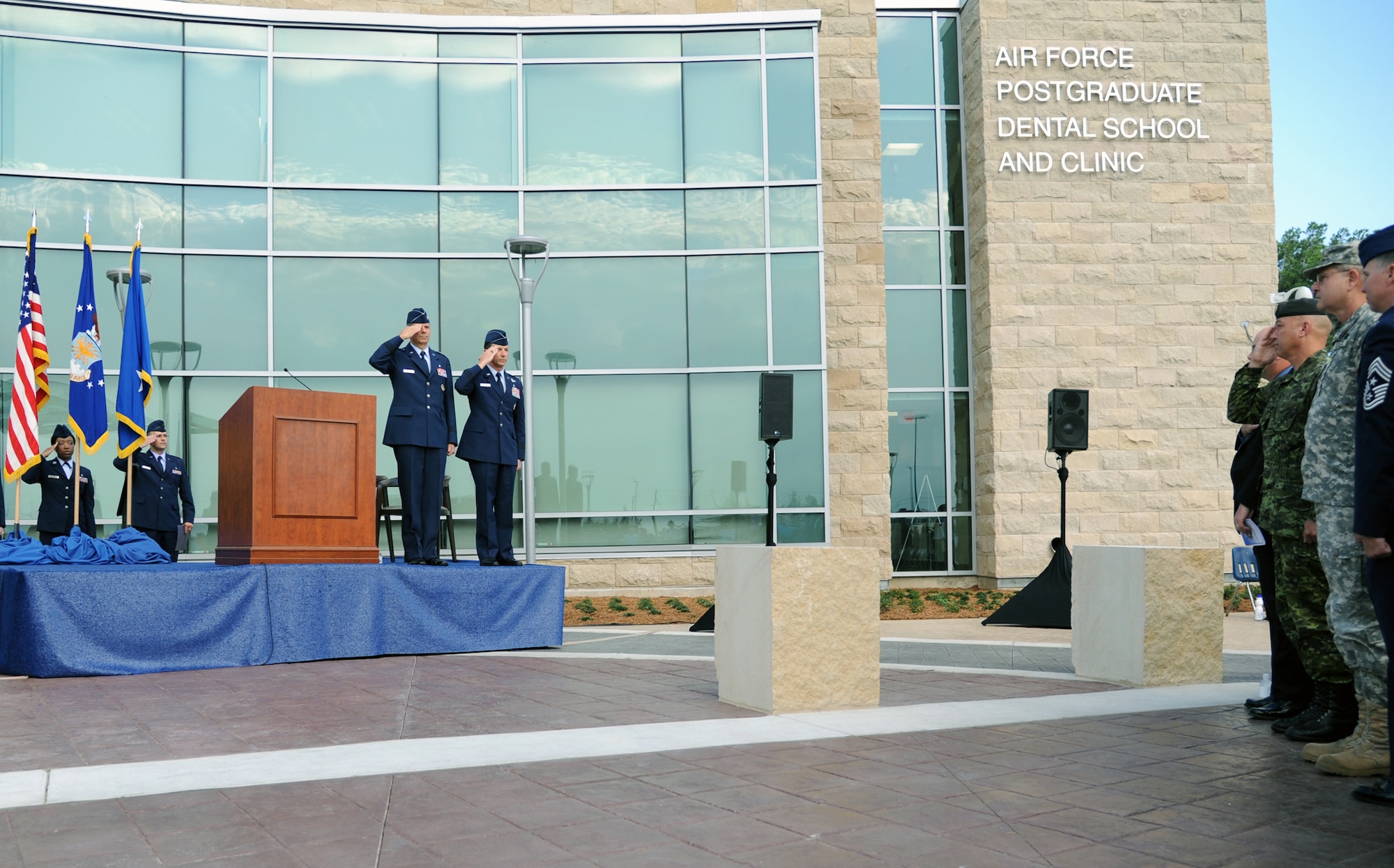 Maj. Gens. Byron Hepburn and Gerard Caron salute during the playing of the national anthem at the ribbon cutting ceremony for the new Air Force Postgraduate Dental School and Clinic, Joint Base San Antonio-Lackland, Texas, June 20. The school is the Air Force flagship for dental education and specialty services. Hepburn is the director of the San Antonio Military Health System and commander of the 59th Medical Wing. Caron is the assistant surgeon general for Dental Services and commander of the 79th Medical Wing. (U.S. Air Force photo/Airman 1st Class Courtney Moses)