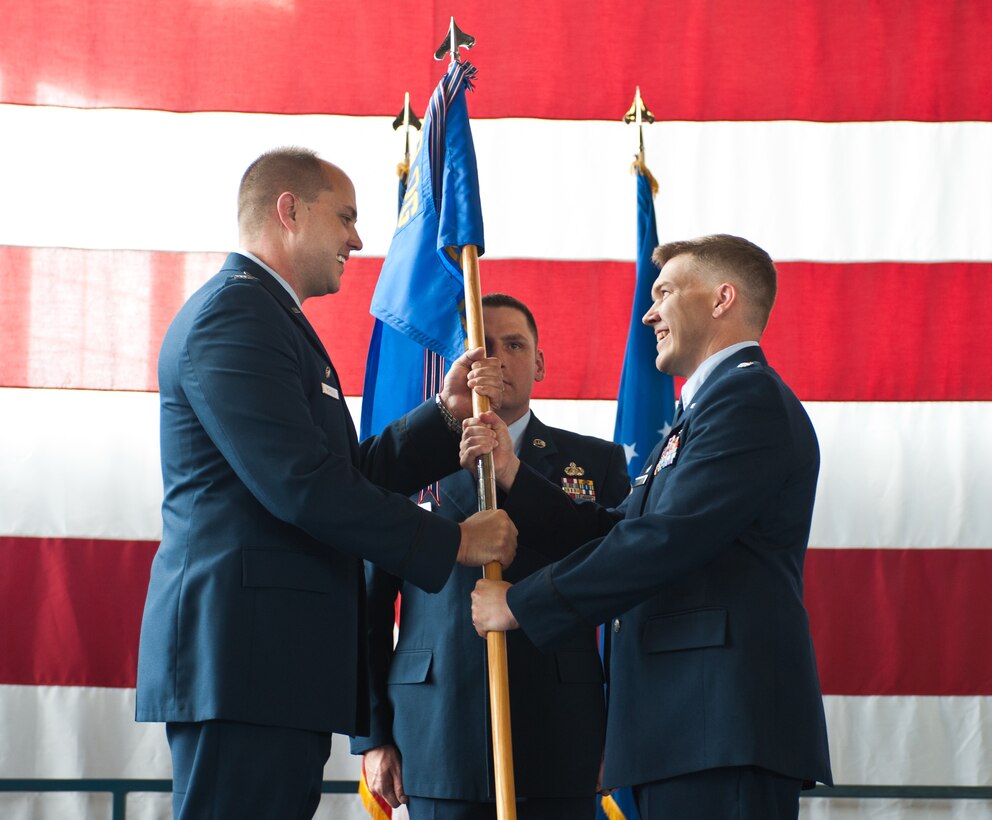 Lt. Col. Brian Farmer (right) accepts command of the 28th Operations Support Squadron from Col. John Nichols, 28th Operations Group commander during a ceremony in the Pride Hangar at Ellsworth Air Force Base, S.D., June 22, 2012. The 28th OSS supports the 28th Bomb Wing in all aspects of flying operations to effectively and efficiently train for and conduct combat operations. (U.S. Air Force photo by Airman 1st Class Alystria Maurer/Released)