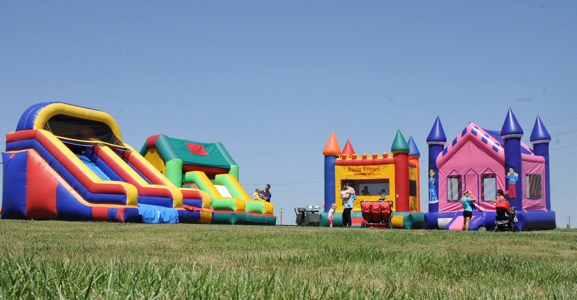 Inflatable jumping castles and slides were set up for people attending the 28th Force Support Squadron “When Nature Calls” event at Heritage Lake Park on Ellsworth Air Force Base, S.D., June 23, 2012. The event, designed to get people outside and enjoy the outdoors, also consisted of a session of yoga, a 5k fun run, a fishing derby and a canoe race. (U.S. Air Force photo by Airman 1st Class Anania Tekurio/Released) 