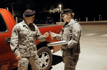 Airman 1st Class Joshua Royer, 902nd SFS installation patrolman, presents his military identification card to Airman 1st Class Melinda Ashley, 902 Security Forces Squadron entry controller, during a routine vehicle inspection at the main gate  of Joint Base San Antonio-Randolph, Texas, June 22. (U.S. Air Force Photo by Don Lindsey)