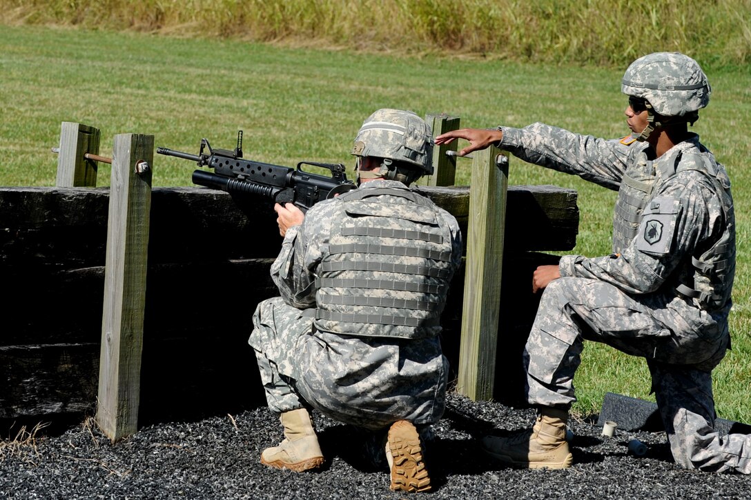 U.S. Army Staff Sgt. Denneit Disla, right, 98th Reserve Division drill sergeant, instructs a Soldier how to fire a M203 Grenade Launcher during an round-robin event as part of the annual Drill Sergeant of the Year competition, June 26, 2012, at Fort Eustis, Va. During the event competitors we’re tested in their knowledge on how to disassemble, reassemble, and perform function checks on a variety of weapons, as well as their ability to walk someone through the proper steps of handling the weapons. (U.S. Air Force photo by Senior Airman Wesley Farnsworth/Released) 