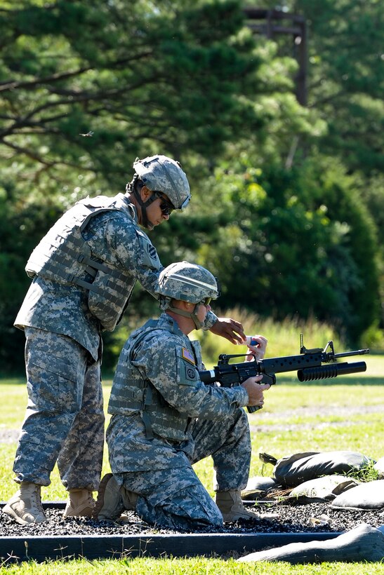 U.S. Army Staff Sgt. Victor Marquez-Rodriguez Sr., Fort Sill, Okla., drill sergeant, hands a practice M-203 round to a Soldier at a event being held as part of the annual week-long Drill Sergeant of the Year event, hosted by Initial Military Training, U.S. Army Training and Doctrine Command, June 26, 2012, at Fort Eustis, Va. At this station Marquez-Rodriguez had to walk the Soldier through the various firing positions as well as how to load and fire the M-203 Grenade Launcher. (U.S. Air Force photo by Senior Airman Wesley Farnsworth/Released) 