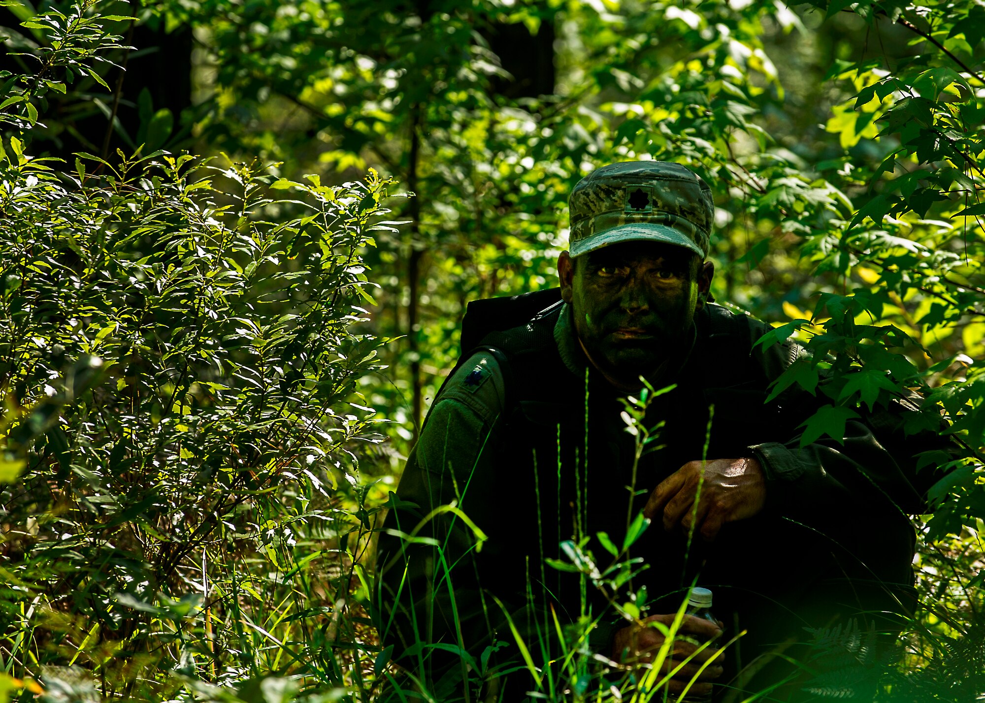 U.S. Air Force Lt. Col. Dave Owens, 15th Airlift Squadron, 437th Airlift Wing commander, waits for a signal to move while navigating terrain during Survival, Evasion, Resistance and Escape Combat Survival Training at Joint Base Charleston - Weapons Station, S.C., June 21, 2012. The 437th Operations Support Squadron conducts the training which is designed for aircrews and other personnel to implement survival techniques to evade enemy forces and to signal friendly forces. (U.S. Air Force photo by Airman 1st Class George Goslin/Released)