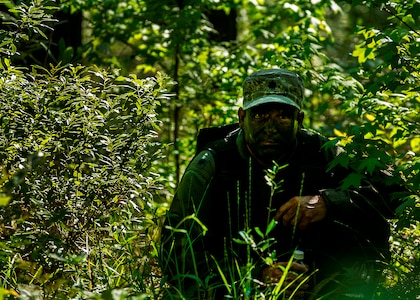 U.S. Air Force Lt. Col. Dave Owens, 15th Airlift Squadron, 437th Airlift Wing commander, waits for a signal to move while navigating terrain during Survival, Evasion, Resistance and Escape Combat Survival Training at Joint Base Charleston - Weapons Station, S.C., June 21, 2012. The 437th Operations Support Squadron conducts the training which is designed for aircrews and other personnel to implement survival techniques to evade enemy forces and to signal friendly forces. (U.S. Air Force photo by Airman 1st Class George Goslin/Released)