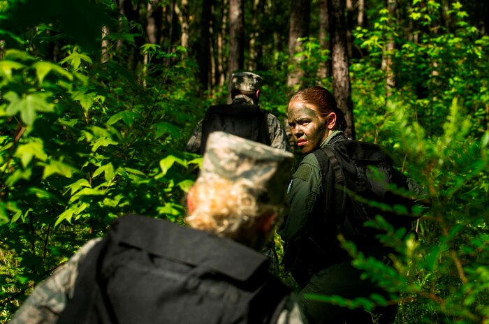 U.S. Air Force Airman 1st Class Brandi Hansen, 1st Combat Camera Squadron broadcaster, navigates the terrain with her group during Survival, Evasion, Resistance and Escape Combat Survival Training at Joint Base Charleston - Weapons Station, S.C., June 21, 2012. The 437th Operations Support Squadron conducts the training which is designed for aircrews and other personnel to implement survival techniques to evade enemy forces and to signal friendly forces. (U.S. Air Force photo by Airman 1st Class George Goslin/Released)