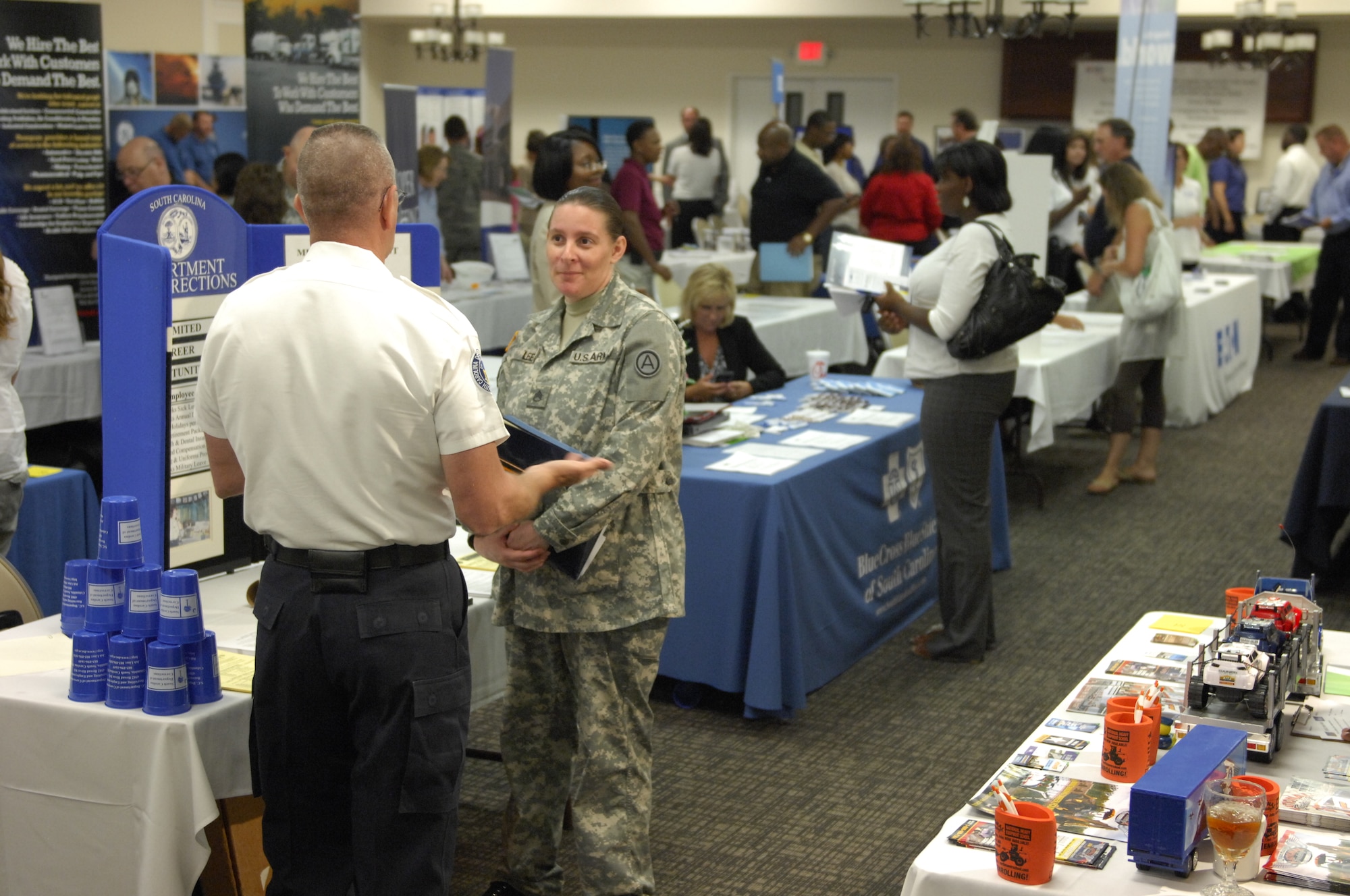 U.S. Army Staff Sgt. Dominique Lee, Third Army/AECENT communication technician, speaks with Dennis Dobbs, Department of Corrections lieutenant recruiter, about potential job opportunities during a job fair at Shaw Air Force Base, S.C., June 22, 2012. The Department of Corrections was one of 38 businesses and universities that set up booths. The fair is geared for retiring military members, their spouses and their dependents. (U.S. Air Force photo by Airman 1st Class Krystal M. Jeffers/ Released)