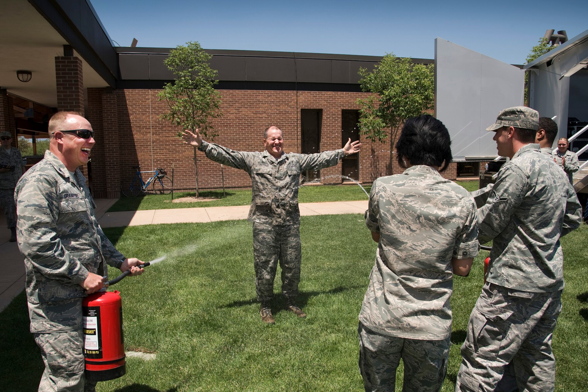 PETERSON AIR FORCE BASE, Colo. – Col. Chris Crawford (left), 21st Space Wing commander, and a few Airmen spray down Chief Master Sgt. Thomas Trottier, 21st SW command chief, with water during his farewell luncheon at the Club June 19, 2012. The watery tradition is popular among some Airmen to say goodbye to a colleague. A large crowd gathered to bid Trottier farewell and thank him for his leadership. Trottier is moving to Seymour Johnson Air Force Base, N.C. (U.S. Air Force photo/Craig Denton)