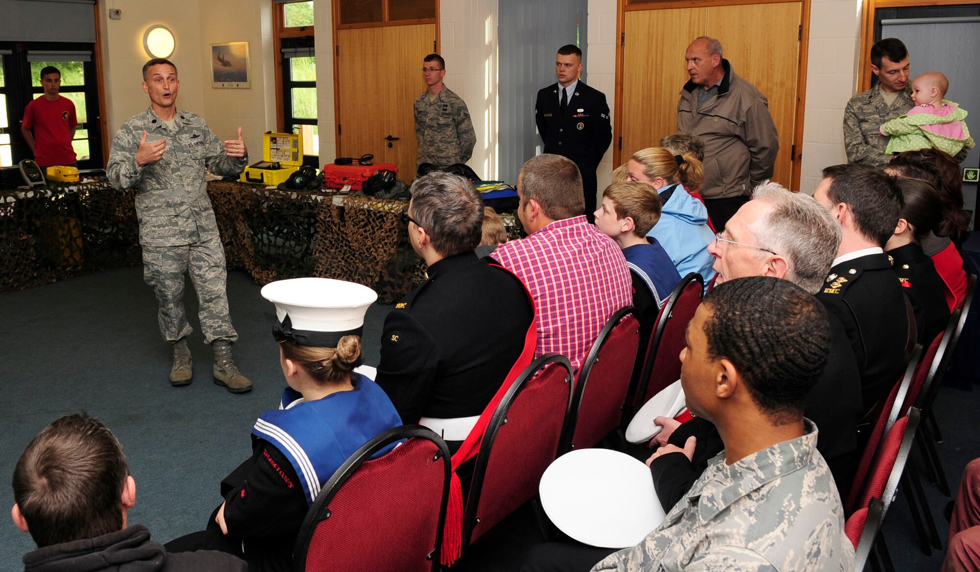 RED LODGE, England – Lt. Col. Gene Mattingly, 100th Communications Squadron commander, talks to teenagers and their families with the local community Sea Cadets Corps at the Millennium Center in Red Lodge June 22, 2012. Mattingly spoke during the first Joint American-British Forces Appreciation Event about the importance of their sea cadet program and how it can teach the same values in them that the U.S. Air Force instills into its Airmen. The commander also showed his appreciation in the cadets for their dedication in the program by coining them. (U.S. Air Force photo/Senior Airman Ethan Morgan)