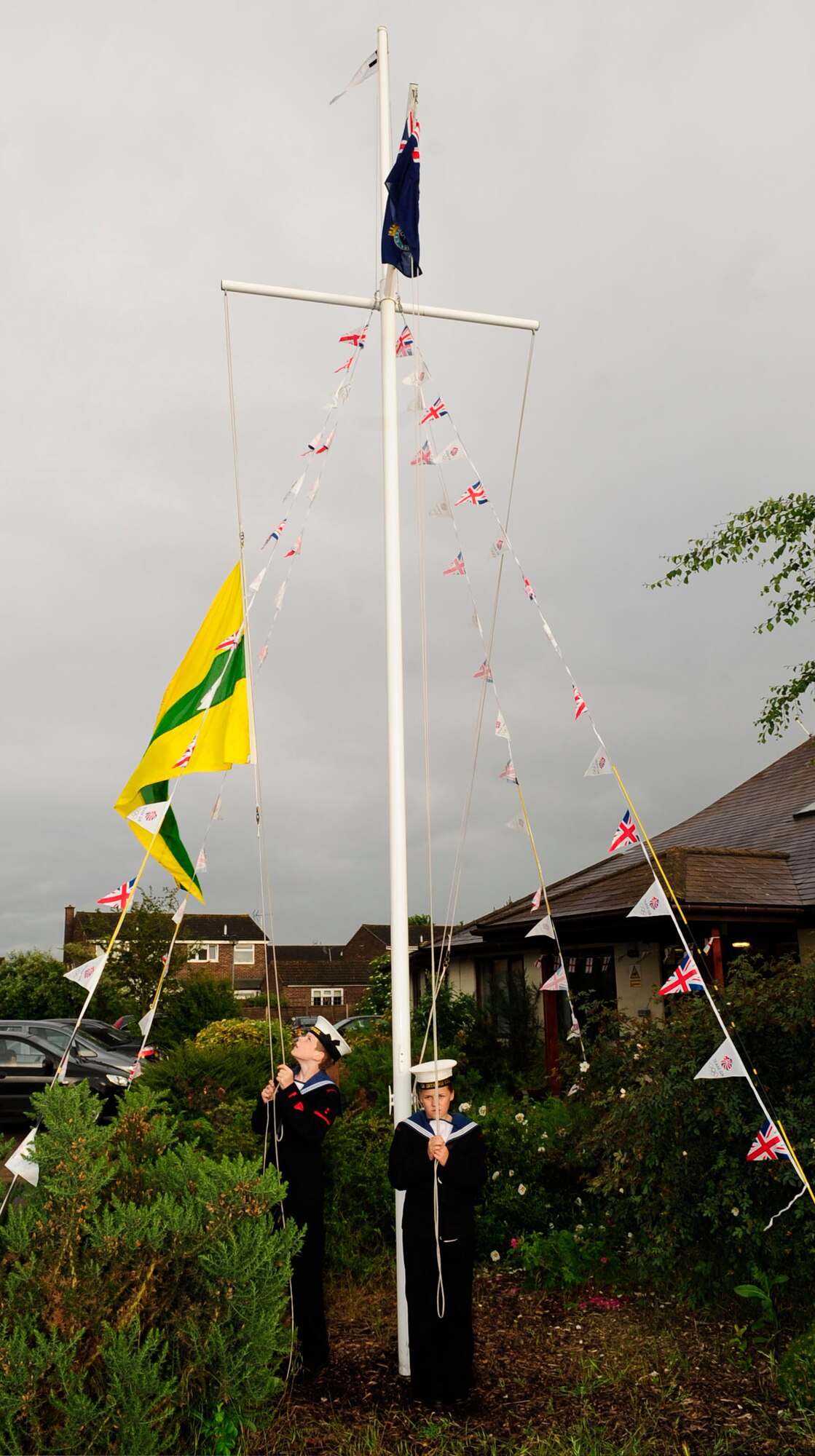 RED LODGE, England – Aaron Coates, Sea Cadets Corps ordinary cadet, and Emma Legate, Sea Cadets Corps cadet, raise the British Cadet Flag during the first Joint American-British Forces Appreciation Event held at the Millennium Center in Red Lodge June 22, 2012. The event was held as a way to help strengthen Team Mildenhall’s bond with the local community.  (U.S. Air Force photo/Senior Airman Ethan Morgan)