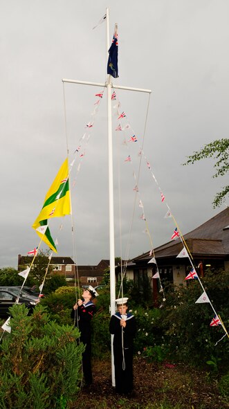 RED LODGE, England – Aaron Coates, Sea Cadets Corps ordinary cadet, and Emma Legate, Sea Cadets Corps cadet, raise the British Cadet Flag during the first Joint American-British Forces Appreciation Event held at the Millennium Center in Red Lodge June 22, 2012. The event was held as a way to help strengthen Team Mildenhall’s bond with the local community.  (U.S. Air Force photo/Senior Airman Ethan Morgan)