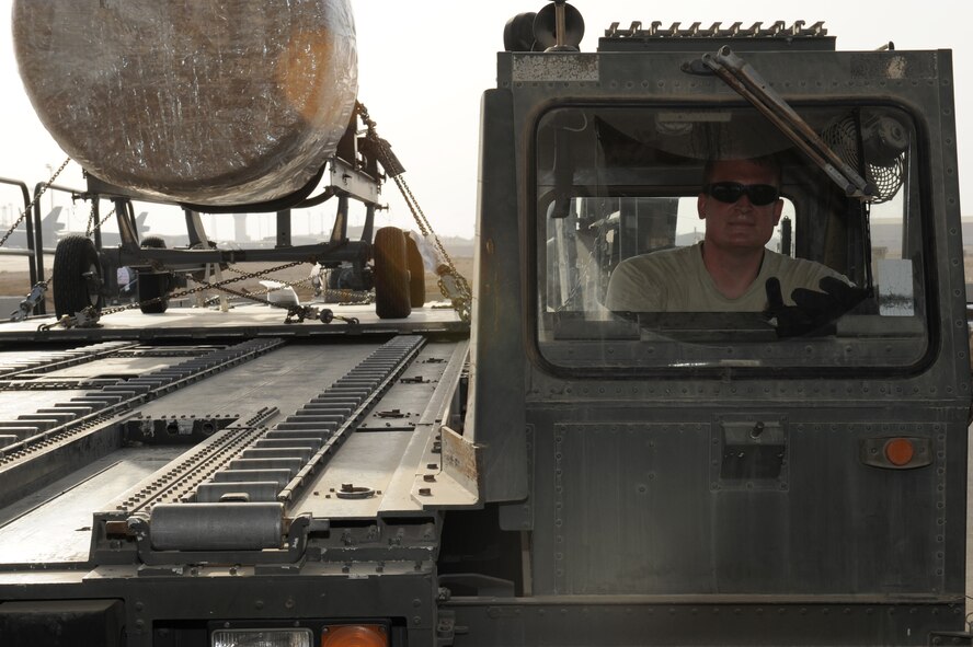 Tech. Sgt. Mark Taylor, 380th Expeditionary Logistics Readiness Squadron Air Terminal Operations Center supervisor, drives a 60 kilo tunner loader carring an aircraft engine June 26, 2012. Taylor is deployed to the 380th Air Expeditionary Wing from Joint Base Andrews, Md. (U.S. Air Force photo/Master Sgt. Scott MacKay) 

