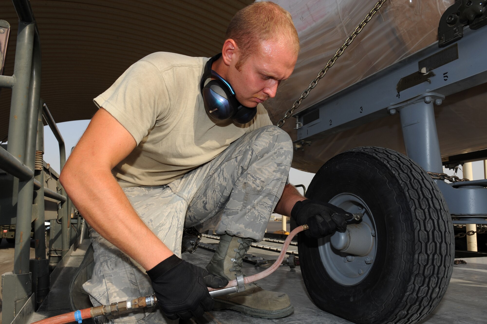 SOUTHWEST ASIA - Senior Airman Zachary Burson, 380th Expeditionary Logistics Readiness Squadron Air Terminal Operations Center technician, inflates a tire on an engine carrier June 26, 2012. Burson is deployed to the 380th Air Expeditionary Wing from Joint Base Andrews, Md. (U.S. Air Force photo/Master Sgt. Scott MacKay)