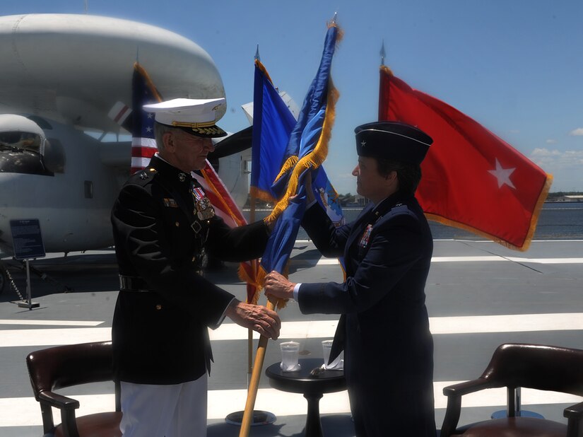 Retired U.S. Marine Corps Maj. Gen. Everett Livingston hands Brig. Gen. Martha Meeker,  senior special assistant to the  Supreme Allied Commander Europe and Commander, U.S. European Command, Supreme Headquarters Allied Powers Europe, Belgium, her new flag moments after being pinned as a brigadier general during a ceremony on USS Yorktown in Mt. Pleasant, S.C. June 22, 2012. Livingston is a Medal of Honor recipient and Meeker was the first commanding officer of Joint Base Charleston. (U.S. Air Force photo/Airman 1st Class Ashlee Galloway)