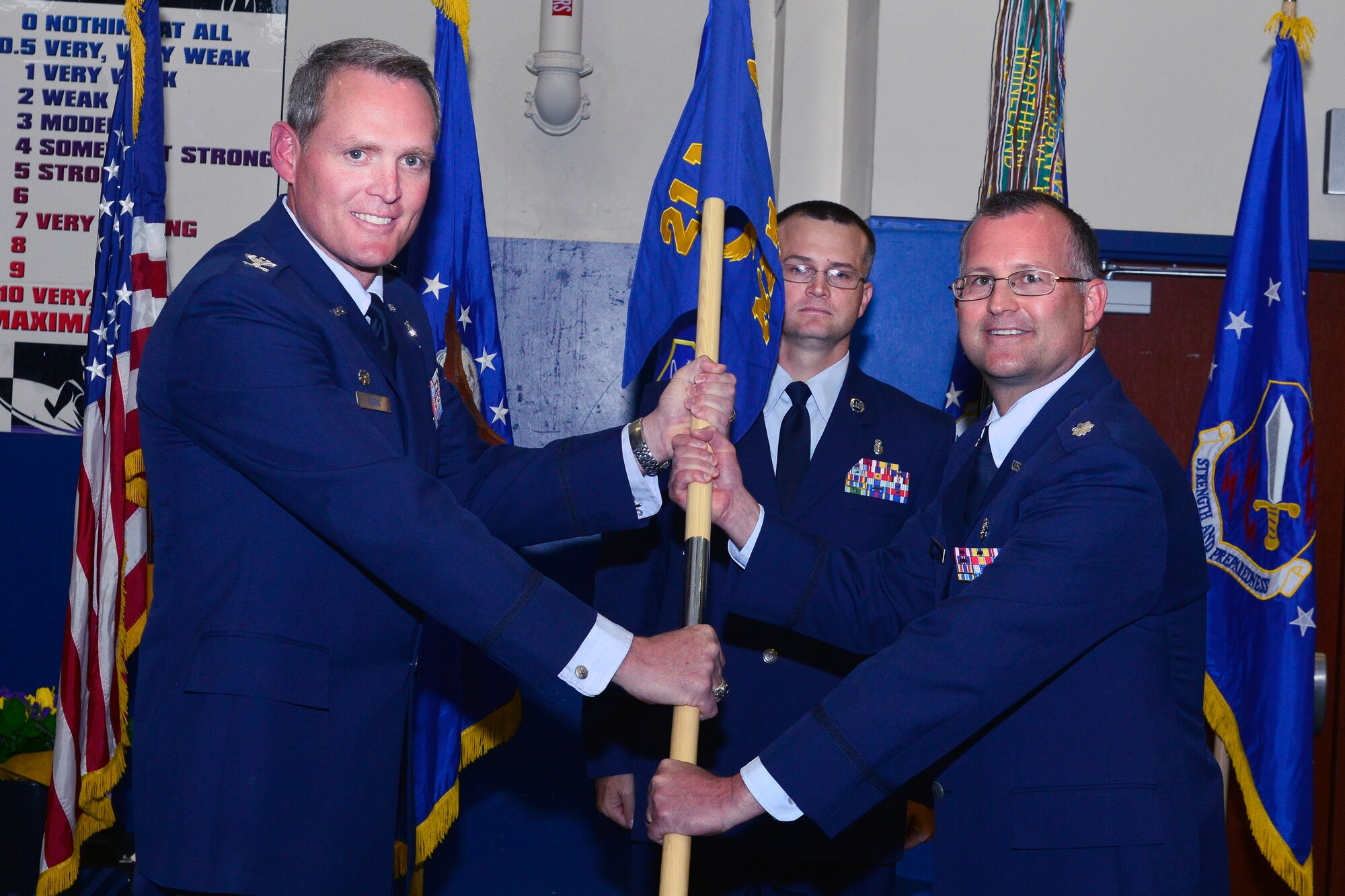 Col. Michael Burke, 21st Medical Group commander, passes the guidon to Lt. Col. Brent Sonday, 21st Medical Squadron commander, during the activation of 21 MDS and assumption of command ceremony June 22 at Schriever Air Force Base. The mission of the squadron will include development of processes to provide seamless, patient-focused care to the Schriever beneficiary population, which includes diagnostic, preventative and treatment related health care services. The squadron will also provide patient education and continuity of care for health maintenance as well as for the acute and chronic management of disease and injury. (U.S. Air Force photo/Bill Evans)