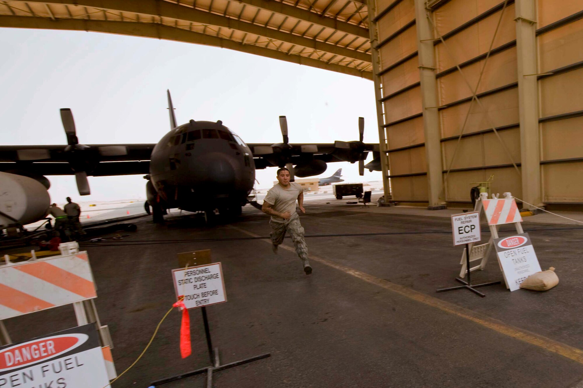 U.S. Air Force Senior Airman Robert Garcia, 379th Expeditionary Maintenance Squadron fuels system journeyman, runs to the nearest office to alert staff members to call fire department, medical services, and the maintenance operations center for a non-responsive airman during an annual confined space extraction exercise in Southwest Asia, June 19, 2012. Garcia is deployed from the 452nd Maintenance Squadron, March Air Reserve Base and a native of Riverside, Calif. (U.S. Air Force photo/Staff Sgt. Sheila deVera)