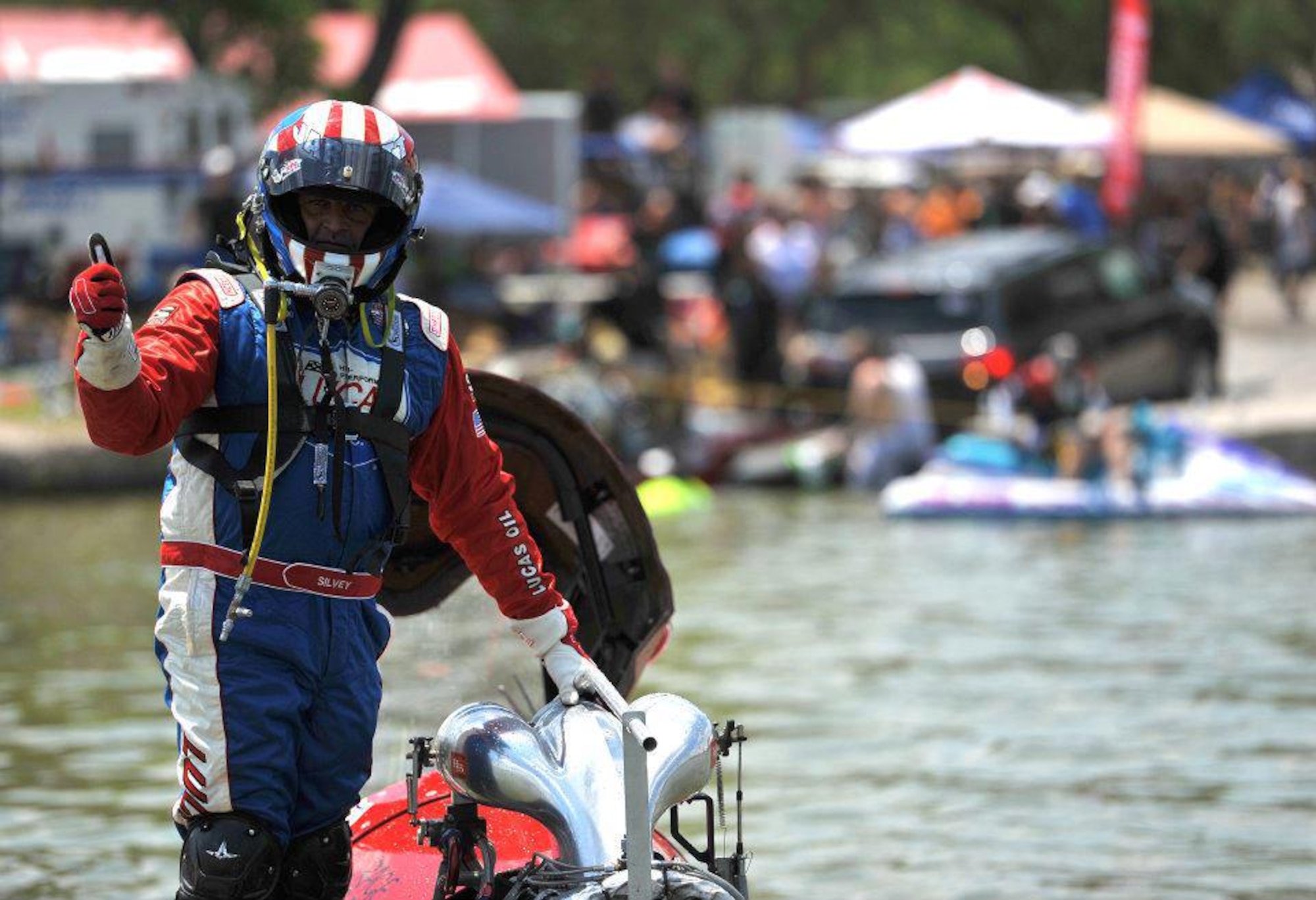 SAN ANGELO, Texas-- Jarrett Siluey, driver of the Speed Sports boat, poses for a photo after his boat experiences engine failure during the Sixth Annual San Angelo Showdown drag boat races at Lake Nasworthy, June 23. Racers wear up to 30 pounds of gear to help protect them in the case of crashes or fires. (U.S. Air Force photo/Airman 1st Class Michael Smith)