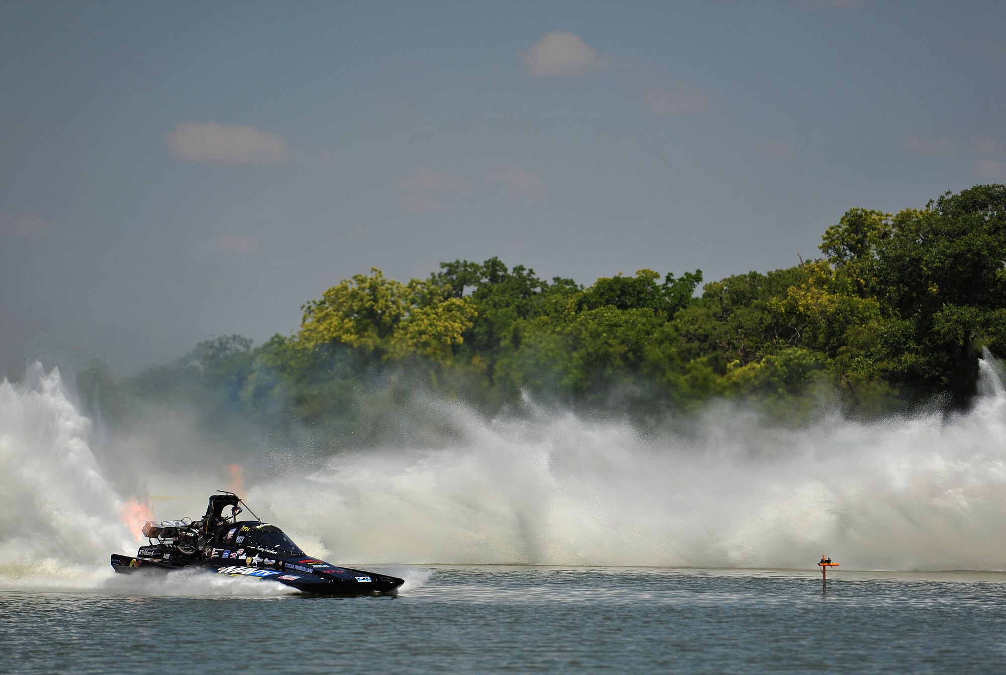 SAN ANGELO, Texas-- Scotty Lumbert, driver of the MAVTV boat, comes out from the starting line with a burst of flames from the engine during the Sixth Annual San Angelo Showdown drag boat races at Lake Nasworthy, June 23.  Lumbert’s boat crashed halfway through the race sending him to the hospital with only minor injuries. (U.S. Air Force photo/Airman 1st Class Michael Smith)