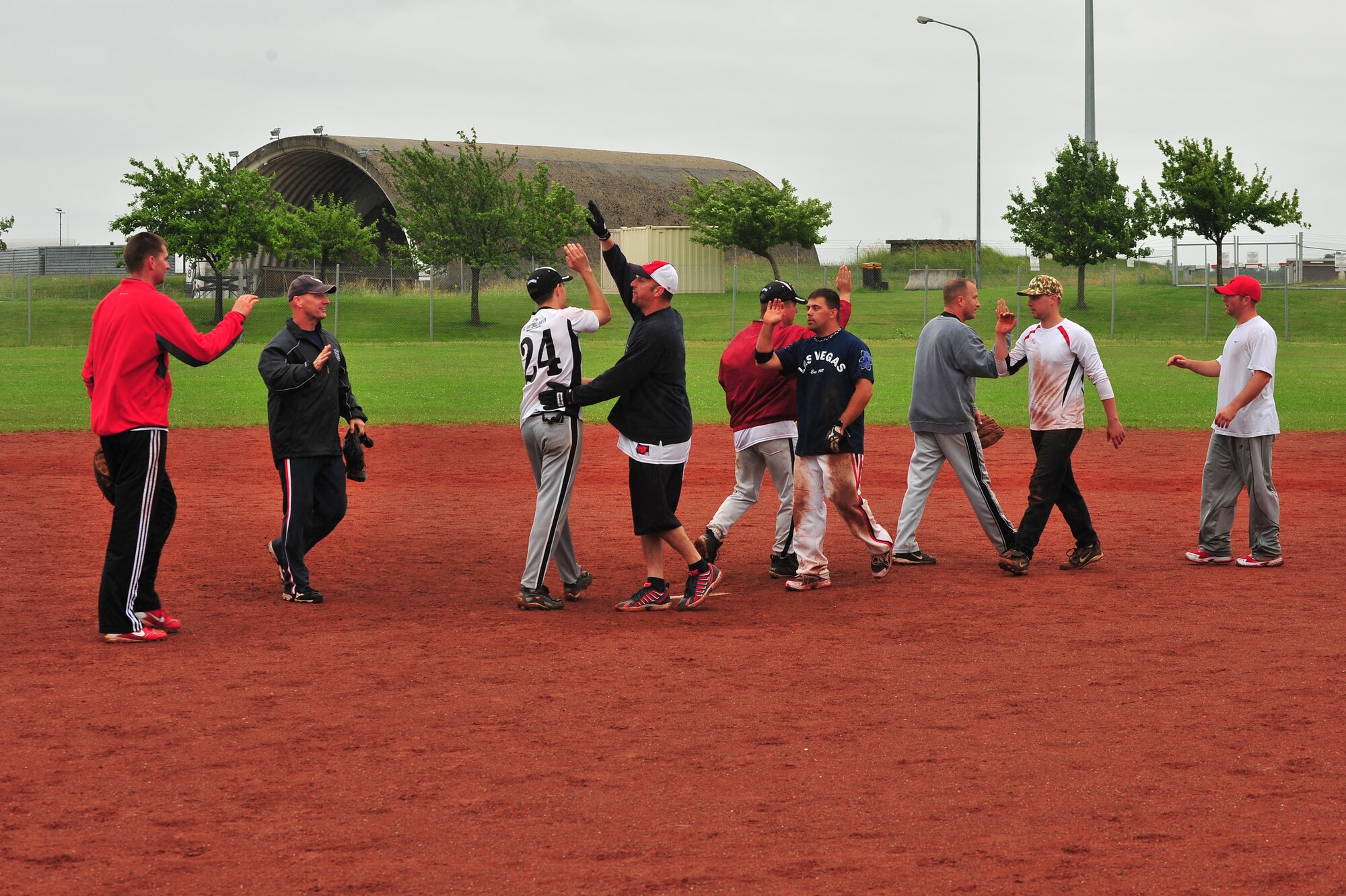 SPANGDAHLEM AIR BASE, Germany – Team members from the Geilenkirchen B Team and LMS Team congratulate one another to show sportsmanship after the first Top IV sponsored Ammo Softball Tournament championship game on Field 2 here June 24. The tournament consisted of 9 teams and spanned three days. (U.S. Air Force photo by Airman 1st Class Dillon Davis/Released)