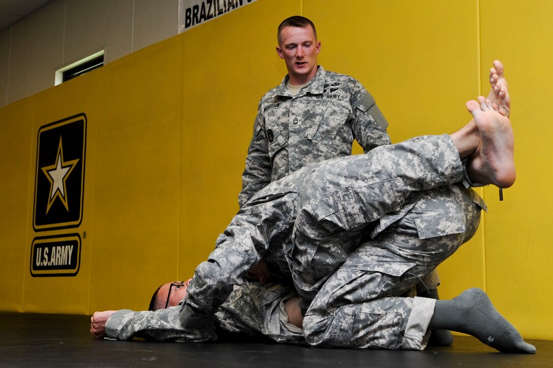 U.S. Army Sergeant 1st Class Adam McQuiston, Fort Leonard Wood, Mo., drill instructor, directs two Soldiers on the proper way to perform a combative move, June 25, 2012, during the annual Drill Sergeant of the Year competition at Fort Eustis, Va. McQuiston is one of six drill sergeants competing in this weeklong competition for the title. (U.S. Air Force photo by Senior Airman Wesley Farnsworth/Released)