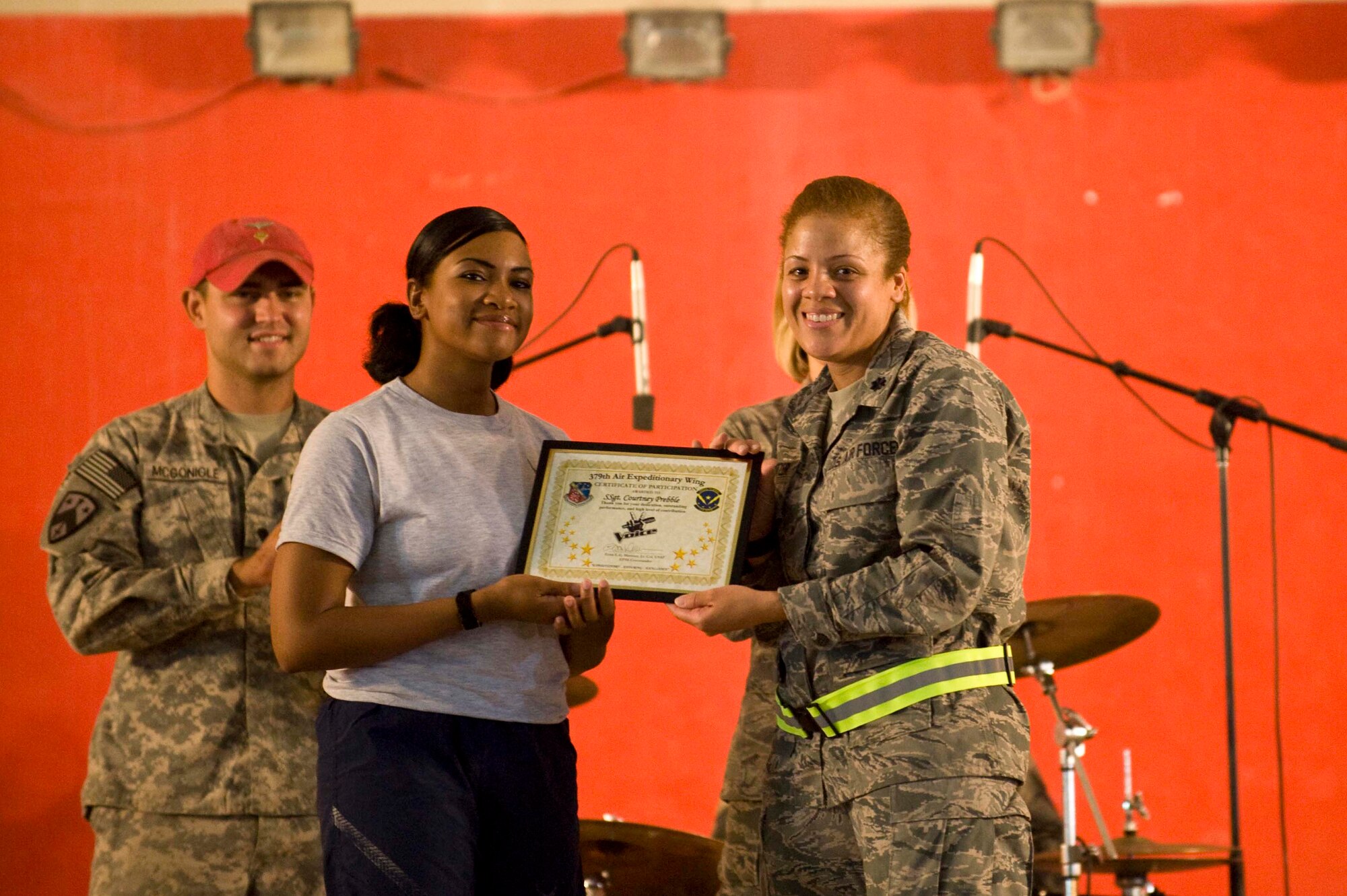 U.S. Air Force Staff Sgt. Courtney Prebble, 379th Expeditionary Security Forces Squadron, poses for a picture with the 379th Expeditionary Force Support Squadron Commander, Lt. Col. Eries Mentzer, after winning the first 379th Air Expeditionary Wing 'The Voice' competition in Southwest Asia, June 23, 2012. For the past four weeks, Prebble survived each elimination round allowing her to compete for the finals. Prebble is deployed from Vanderberg Air Force Base, Calif., and is a native of Hampton, Va. (U.S. Air Force photo/Staff Sgt. Sheila deVera)

