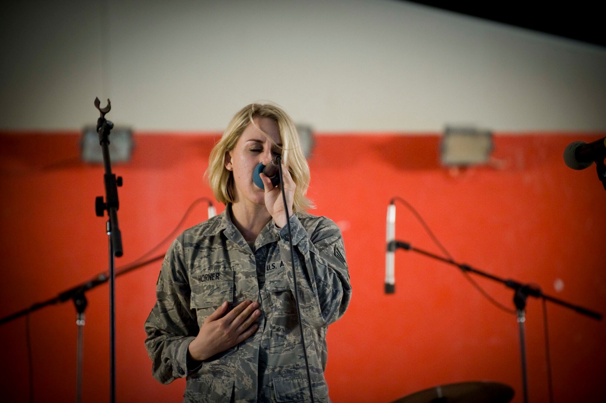 U.S. Air Force Senior Airman Jamie Horner, 379th Expeditionary Civil Engineer Squadron, competes with two other finalist for the 379th Air Expeditionary Wing 'The Voice' competition in Southwest Asia, June 23, 2012. For the past four weeks, each singer survived the elimination round advancing to the next round. Horner is deployed from Andrews Air Force Base, Md., and is a native of Redding, Calif. (U.S. Air Force photo/Staff  Sgt. Sheila deVera)