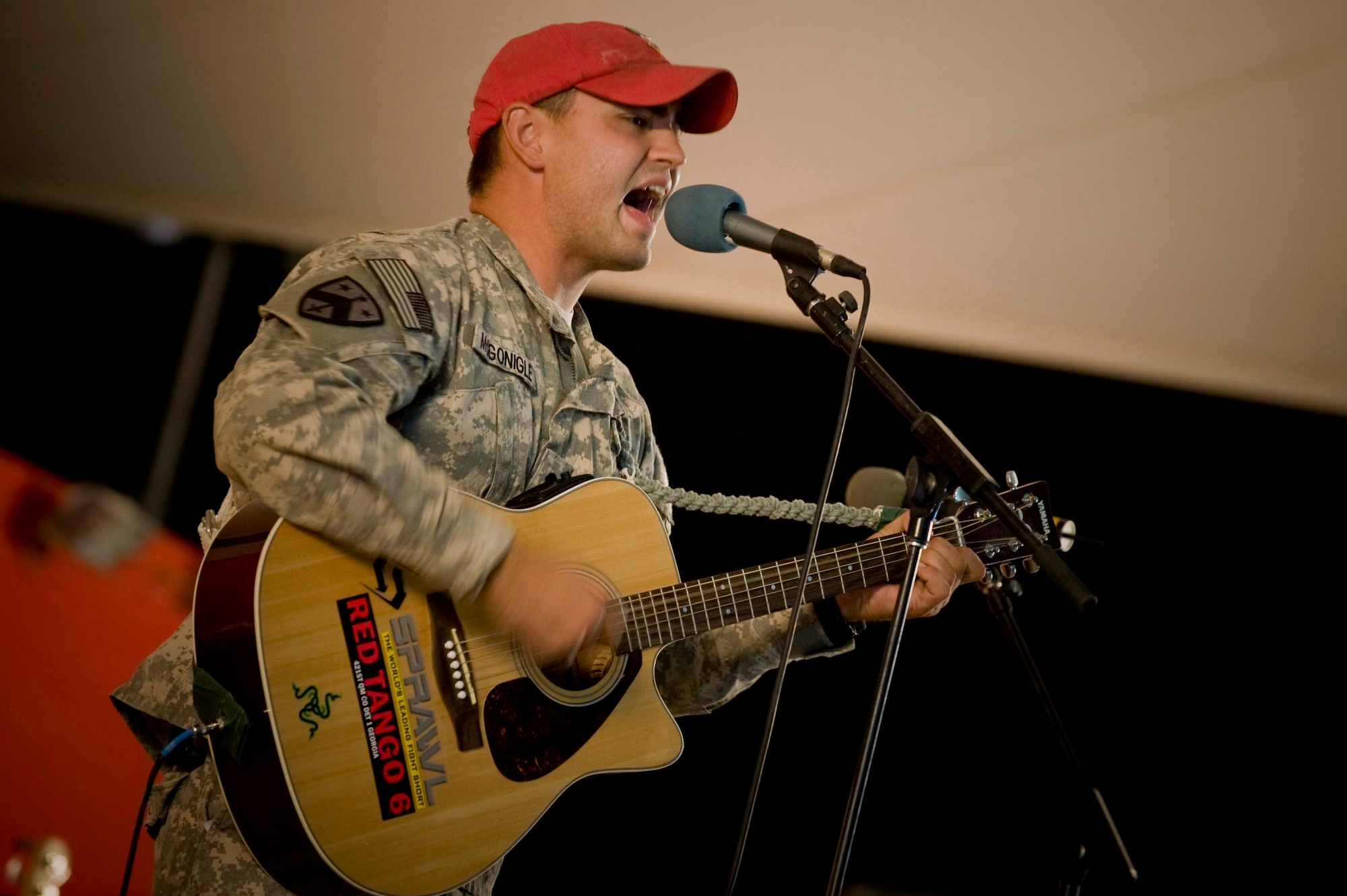 U.S. Army Specialist Joshua McGonigle competes with two other finalists for the 379th Air Expeditionary Wing 'The Voice' competition in Southwest Asia, June 23, 2012. For the past four weeks, each singer survived the elimination round advancing to the next round. McGonigle is assigned to the 421st Quartermaster Riggers Detachment 1 and is a native of Locust Grove, Ga.  (U.S. Air Force photo/Staff Sgt. Sheila deVera)