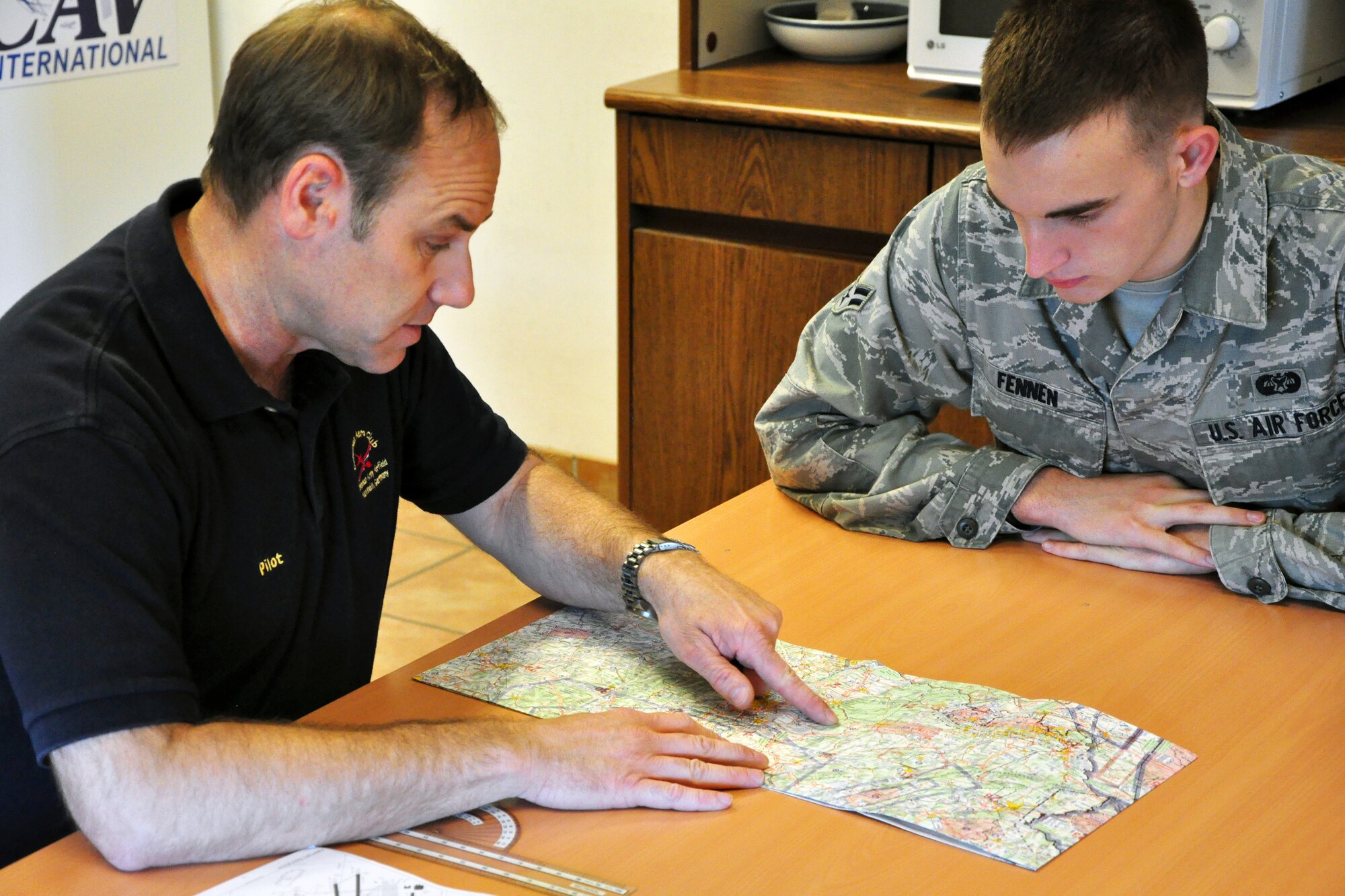 Lt. Col. Rich Radvanyi, pilot and president of the Coleman Aero Club, goes over the incentive flight route with Airman 1st Class Nicholas Fennen, 86th Airlift Wing Judge Advocate discharge paralegal, at Ramstein Air Base, Germany, June 22, 2012. Fennen was selected to participate in the Ramstein Daedalians Aviation Incentive Flight program, which provides quarterly aviation incentive flights to deserving young Airmen and gives them the chance to live a childhood fantasy of flight. (U.S. Air Force photo/Tech. Sgt. Chad Thompson)