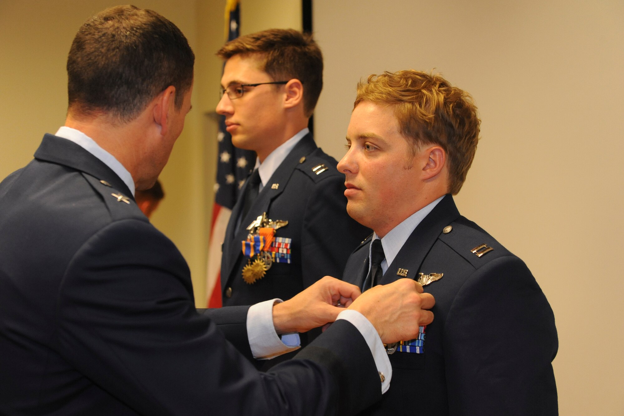 U.S. Air Force Capt. Louis Nolting, 33rd Rescue Squadron flight safety officer, receives the Air Force Combat Action Medal from Brig. Gen. Matthew Molloy, 18th Wing commander, at the 33rd RQS auditorium on Kadena Air Base, Japan, June 20, 2012. The principal eligibility criterion is that the individual must have been under direct and hostile fire while operating in unsecured space (outside the defended perimeter), or physically engaging hostile forces with direct and lethal fire.  (U.S. Air Force photo/Airman 1st Class Justin Veazie)