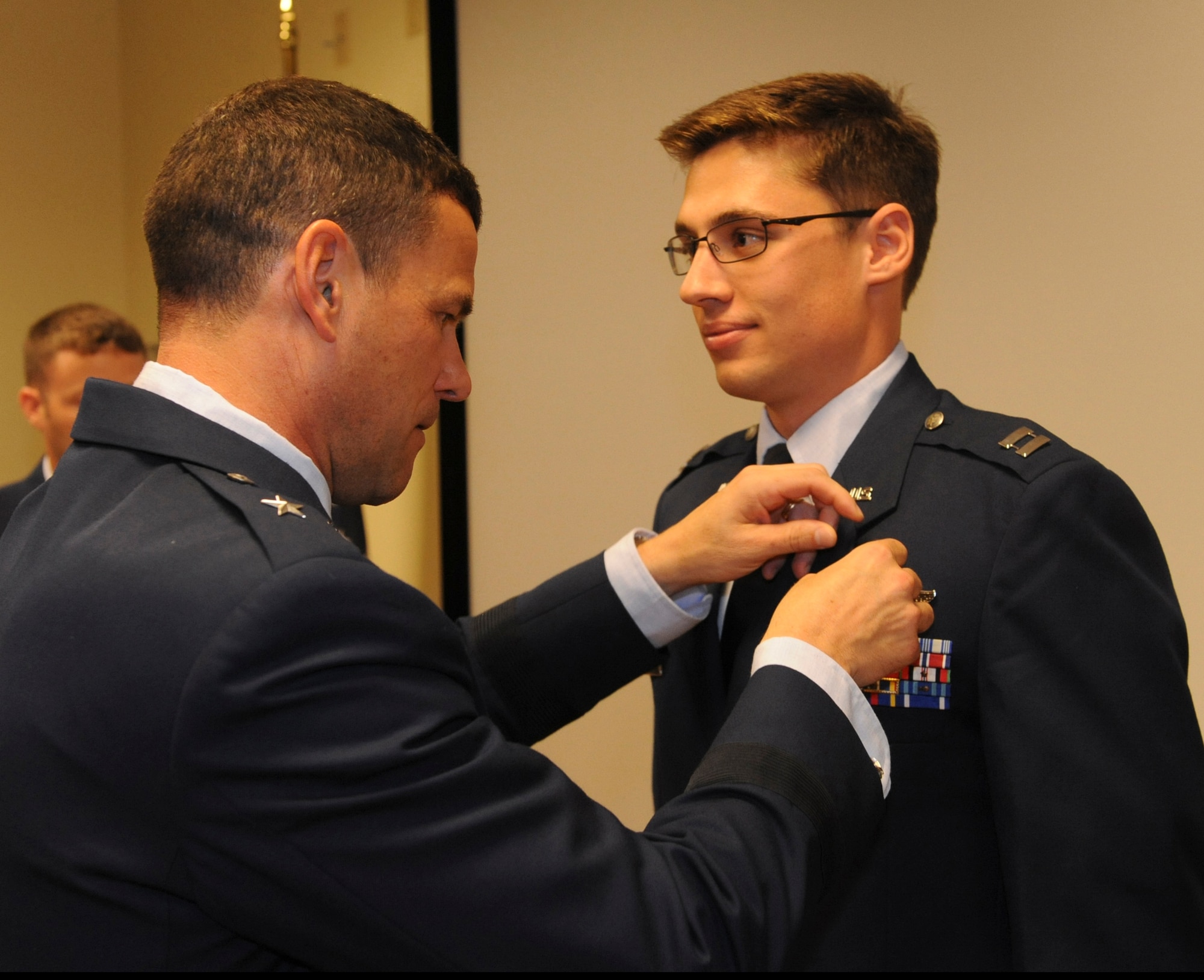 U.S. Air Force Capt. Elliot Milliken, 33rd Rescue Squadron pilot, receives the Air Force Combat Action Medal from Brig. Gen. Matthew Molloy, 18th Wing commander, at the 33rd RQS auditorium on Kadena Air Base, Japan, June 20, 2012. Milliken and another HH-60 Pave Hawk pilot, Capt. Louis Nolting, were among six 33rd RQS Airmen recognized for their actions while deployed to Bagram Airfield, Afghanistan, last year. Three Air Force Commendation Medals and three Air Medals were also awarded to the captains and several coworkers. (U.S. Air Force photo/Airman 1st Class Justin Veazie)