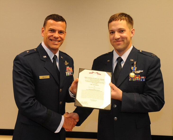 U.S. Air Force Capt. Kevin Pieper, 33rd Rescue Squadron receives the Air Medal from Brig. Gen. Matthew Molloy, 18th Wing commander, at the 33rd RQS auditorium on Kadena Air Base, Japan, June 20, 2012. Pieper was among seven 33rd RQS Airmen presented medals for various achievements including deployment actions in Afghanistan.  (U.S. Air Force photo/Airman 1st Class Justin Veazie)