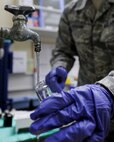 U.S. Air Force Tech. Sgt. John Horgan, 18th Aerospace Medicine Squadron, Bioenvironmental Engineering Flight, demonstrates the steps in taking a water sample on Kadena Air Base, June 25, 2012. Horgan and his fellow Airmen from the Bioenvironmental Engineering Flight have taken water samples throughout the year to build an annual Consumer Confidence Report that lets the public know the quality of water on the air base, as well as the military family housing units around Okinawa. (U.S. Air Force photo/Staff Sgt. Laszlo Babocsi)