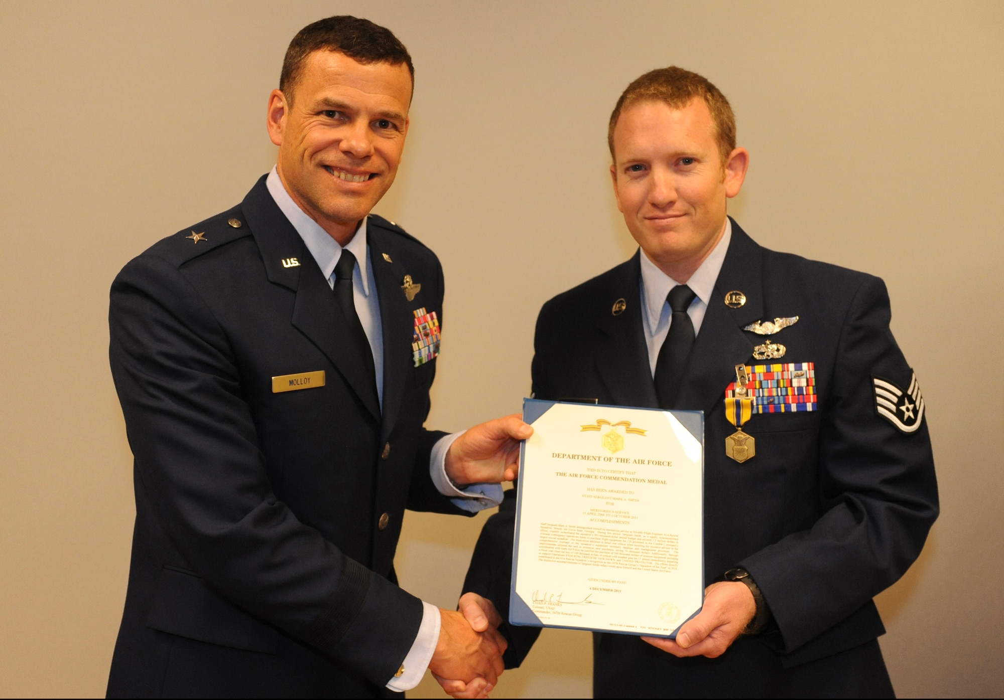 U.S. Air Force Staff Sgt. Mark Smith, 33rd Rescue Squadron, receives the Air Force Commendation Medal from Brig. Gen. Matthew Molloy, 18th Wing commander, at the 33rd RQS auditorium on Kadena Air Base, Japan, June 20, 2012. Smith was among seven 33rd RQS Airmen presented medals for various achievements including deployment actions in Afghanistan. (U.S. Air Force photo/Airman 1st Class Justin Veazie)