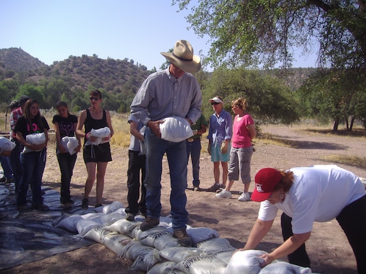 The prepared sandbags are stacked by participating community members.