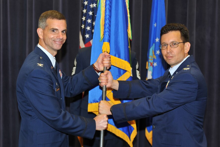 OFFUTT AIR FORCE BASE, Neb. -- Col. Louis Zuccarello, Air Force Weather Agency commander, hands the 1st Weather Group guidon to Col. William Carle, signifying the official change of command for the group during a ceremony at AFWA's Chief Master Sgt. Peter Morris Auditorium June 25. Carle, who comes to the 1st WXG from the Pentagon, assumed command from Col. Kay Smith, who now leaves for Maxwell AFB, Ala. (Air Force photo by Jeff Gates)