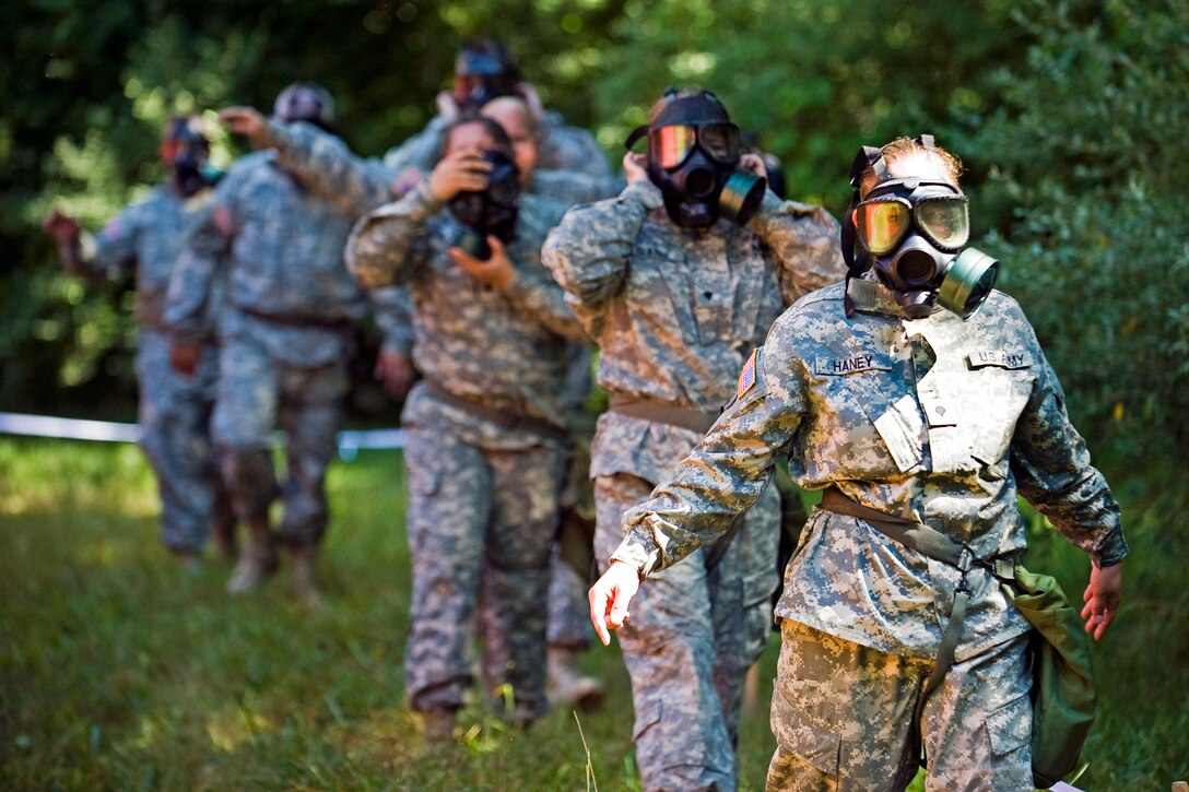 Soldiers exit the gas chamber after being exposed to tear gas during a simulated chemical weapons attack on Camp Atterbury, Ind., June 22, 2012.