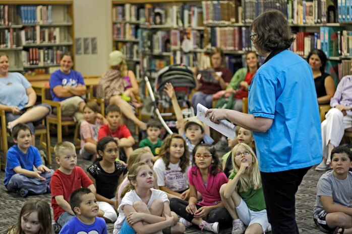 Stacey Kobe-Bellika, station supervisory librarian, speaks to participants of Potato Chip Day, which took place inside the Building 411 library here, June 27, 2012. The event consisted of stories and history about potatoes and potato chips and a potato chip taste testing game where participants tried to guess the flavor of different chips.