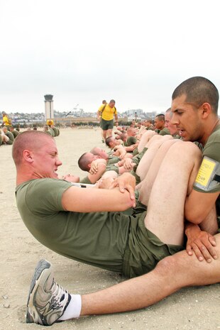 Recrutis from Company H, 2nd Recruit Training Battalion, do their max set of crunches in a span of two minutes as one part of their final physical fitness test June 14 aboard Marine Corps Recruit Depot San Diego. The PFT is comprised of a max set of pull-ups, a timed three-mile run and a max set of crunches in two minutes. For a perfect score recruits and Marines must complete 20 pull-ups, an 18 minute or below three mile and 100 crunches in two minutes.