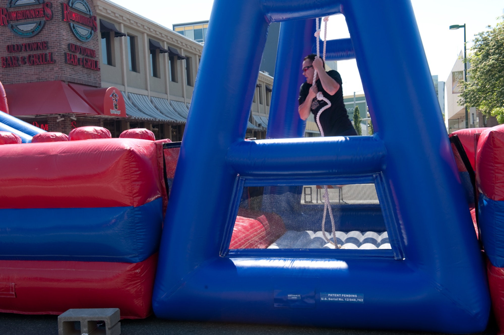 A member of the Anchorage Police Department Employees Association swings on a rope inside an inflatable obstacle course during the Hero Games, part of the Solstice festival, in downtown Anchorage, Alaska June 23. Teams made up of Active Duty Army, Air Force, Guard, Reserve, the APD, fire department and other units participated in the friendly competition designed to improve morale and relations between the different units. On the longest day of the year-summer solstace-Anchorage, Alaska, gets 22 hours of functional daylight. (U.S. Air Force photo/Staff Sgt. Robert Barnett)