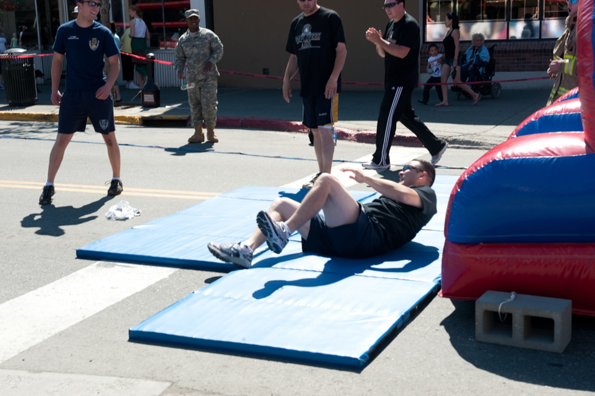 A member of the Anchorage Police Department Employees Association rolls out of an inflatable obstacle course during the Hero Games, part of the Solstice festival, in downtown Anchorage, Alaska June 23. Teams made up of Active Duty Army, Air Force, Guard, Reserve, the APD, fire department and other units participated in the friendly competition designed to improve morale and relations between the different units. On the longest day of the year-summer solstace-Anchorage, Alaska, gets 22 hours of functional daylight. (U.S. Air Force photo/Staff Sgt. Robert Barnett)