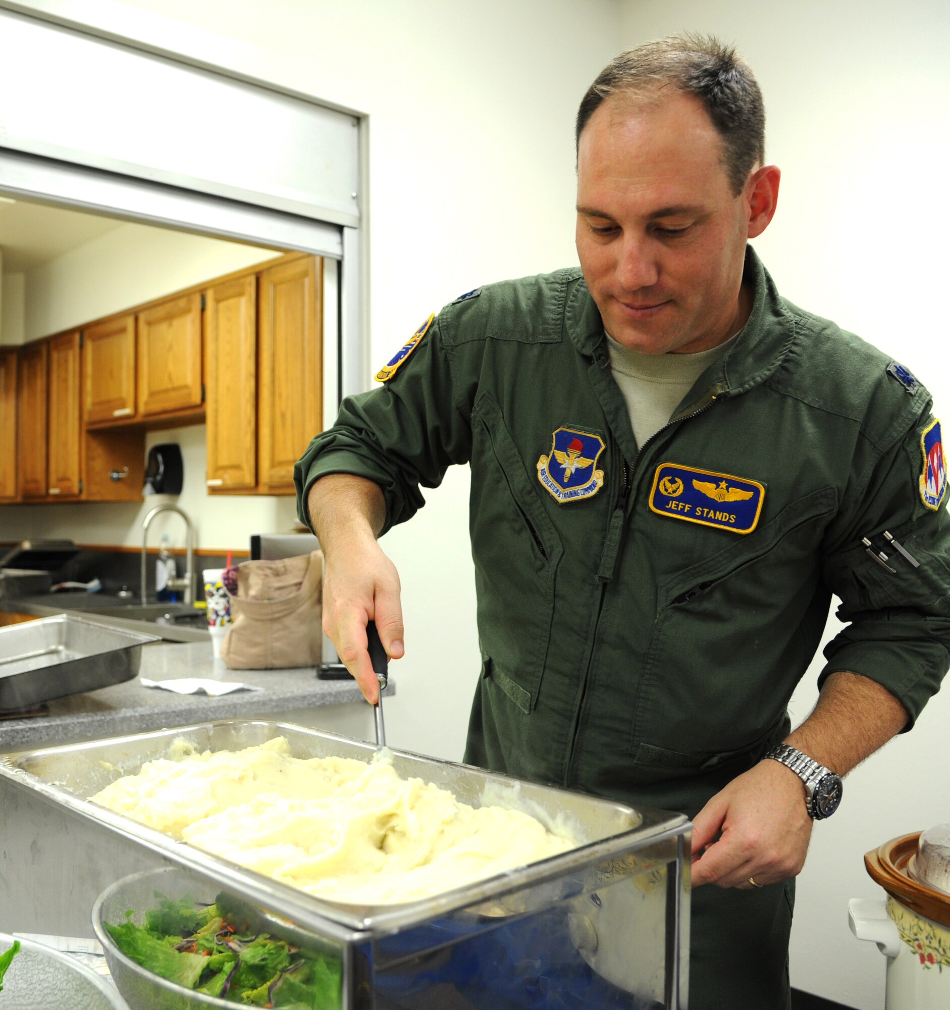 Lt. Col Jeff Stands, the commander of the 25th Flying Training Squadron, stirs up mashed potatoes during the Singles’ International Gourmet Meal Opportunity at Vance Air Force Base, Okla.  SIGMO provides a free meal for single Airmen, and to families with deployed spouses, at the end of each month.  (U.S. Air Force photo/ Airman 1st Class Frank Casciotta)