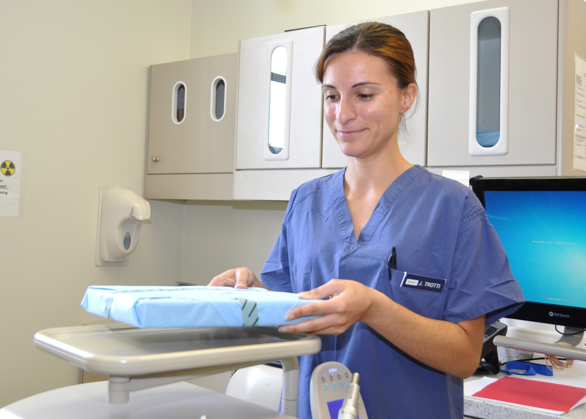Staff Sgt. Joana Trotti, 81st Dental Squadron, places a sterilized instrument kit on a tray in a dental treatment room June 17, 2012, at Keesler Air Force Base, Miss.  Trotti was selected into the nurse enlisted commissioning program June 13. (U.S. Air Force photo by Steve Pivnick)