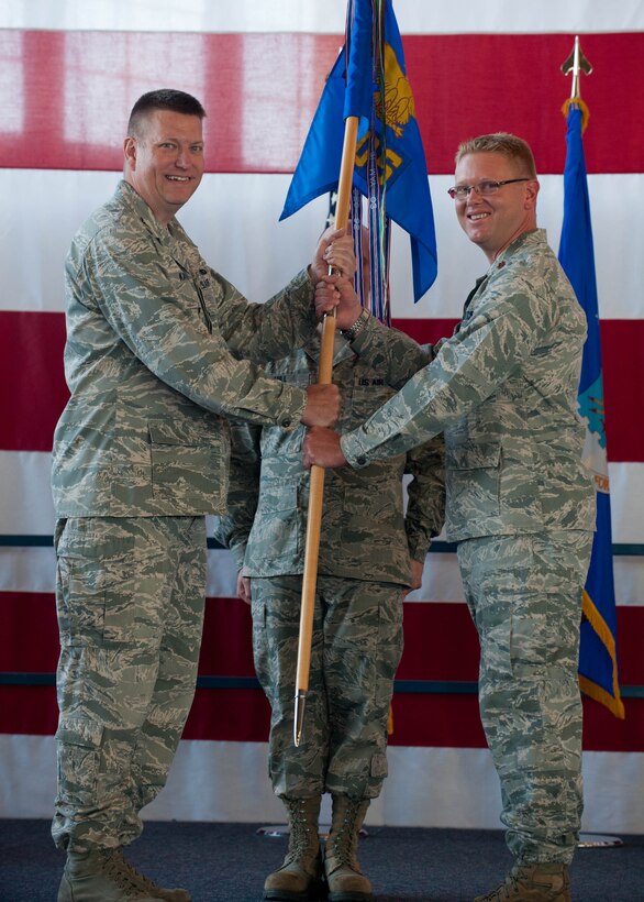 Maj. Larry Rochat (right) accepts command of the 28th Maintenance Operations Squadron from Col. James Katrenak, 28th Maintenance Group commander, during a ceremony in the Pride Hangar at Ellsworth Air Force Base, S.D., June 22, 2012. The 28th MOS ensures the capability of B-1 bombers assigned to the 28th Bomb Wing and the efficient utilization of all wing maintenance assets. (U.S. Air Force photo by Airman 1st Class Zachary Hada, Released)
