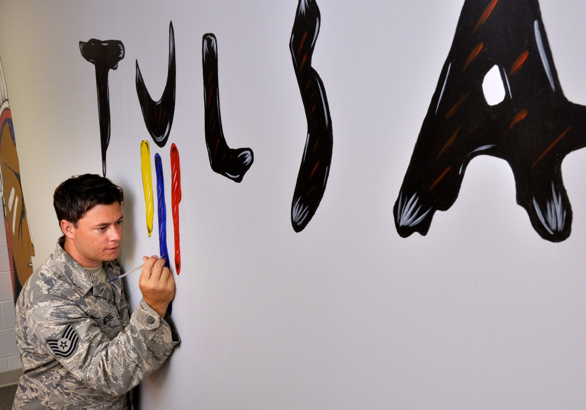 Technical Sergeant Michael T. Craig, 138th Fighter Wing Aircrew Flight Equipment Specialist, touches up some his art work that leads into his work area at the 125th Fighter Squadron, Oklahoma Air National Guard, Tulsa, OK.  TSgt Craig has been adorning the facility with his work since he joined the unit in September 2008.
