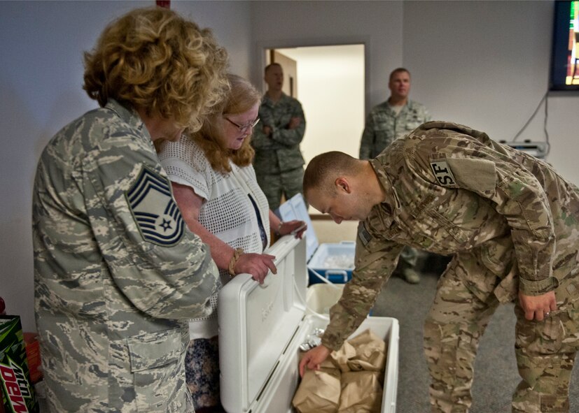 U.S. Air Force Airman 1st Class Jacob Lilieholm from the 440th Security Forces Squadron at Pope Air Force Base, N.C., takes a hot dog snack bag donated by Chief Master Sgt. Dianna Vallely, 23d Medical Group chief enlisted manager, and Patricia Wittenborn, 23d Force Support Squadron Airman and Family Readiness Center unit liaison, June 26, 2012, at Moody Air Force Base, Ga. Lillieholm and many other Airmen from different bases left for a deployment to Afghanistan and will be downrange for six months with Moody’s 824th Base Defense Squadron. (U.S. Air Force photo by Senior Airman Eileen Meier/Released) 